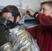 USS John C. Stennis sailor helps put on face mask