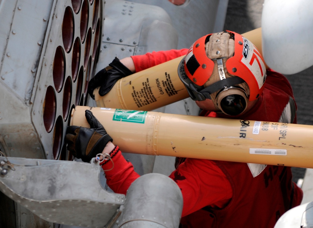 Loading ordnance into an MH-60S Sea Hawk helicopter