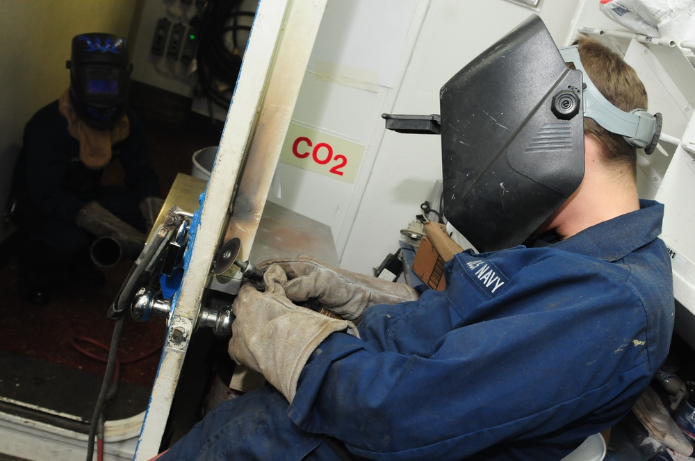 USS Kearsarge sailor repairs door