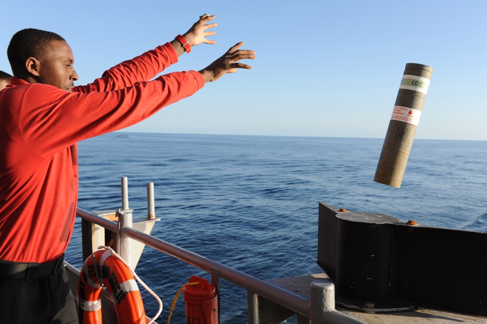 USS Dwight D. Eisenhower sailor throws smoke marker