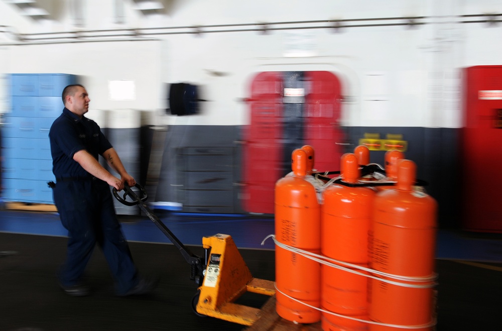 USS George H.W. Bush sailor transports bottles