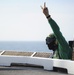 USS George H.W. Bush sailor signals pilot