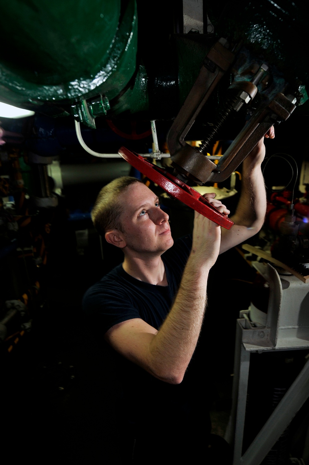 USS Carl Vinson sailor performs maintenance on valve