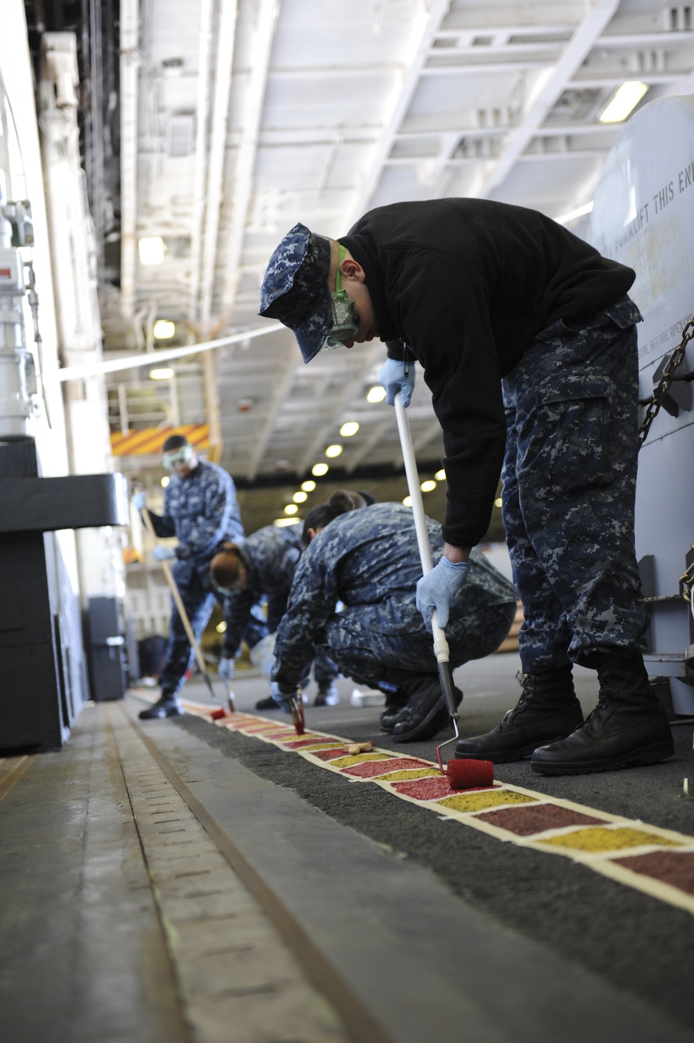 USS Nimitz sailors touch-up the hangar bay