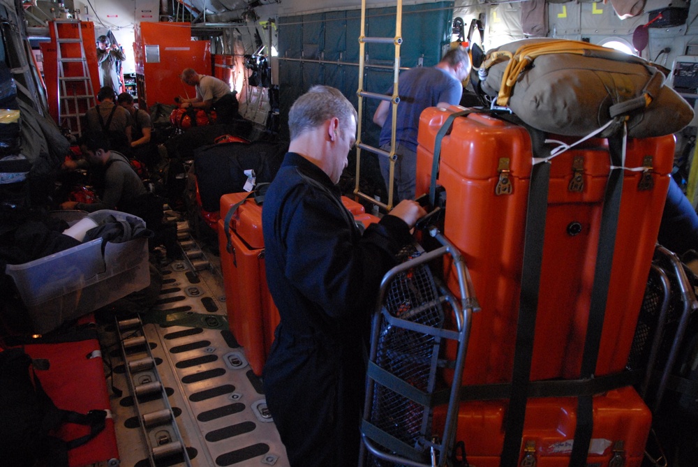 Coast Guard rescue plane drops supplies to injured sailors.