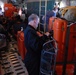 Coast Guard rescue plane drops supplies to injured sailors.