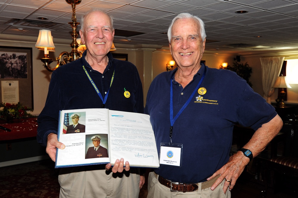Retired USS Dwight D. Eisenhower officers hold cruise book