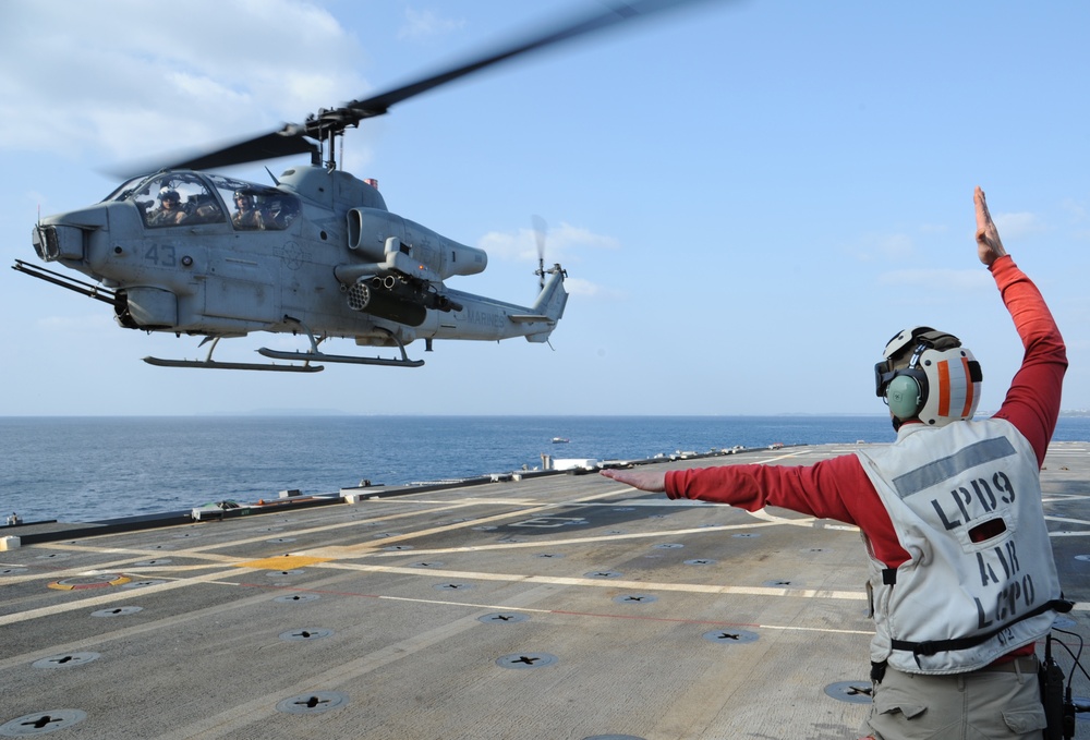 Signaling  to the pilot of an AH-1W Cobra helicopter