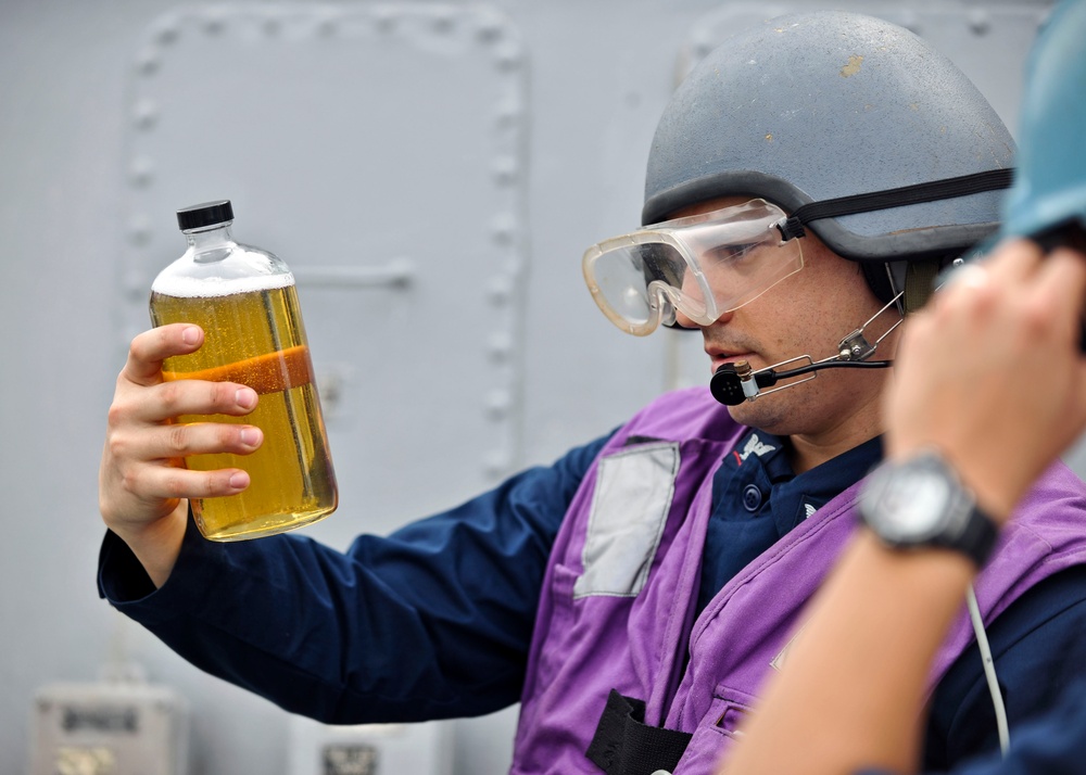 USS Porter sailor checks fuel