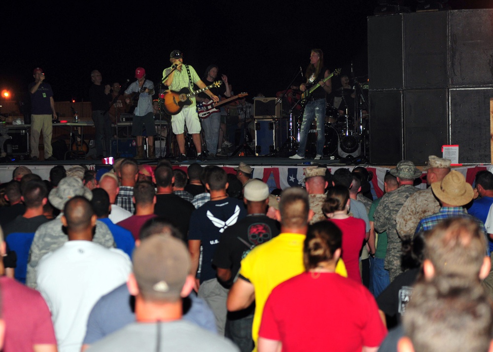 Award-winning country music superstar Toby Keith speaks in between the song to the 2500 Army, Navy, Air Force, Marines, French military, Japanese military, and civilian employees watching the concert at Camp Lemonnier