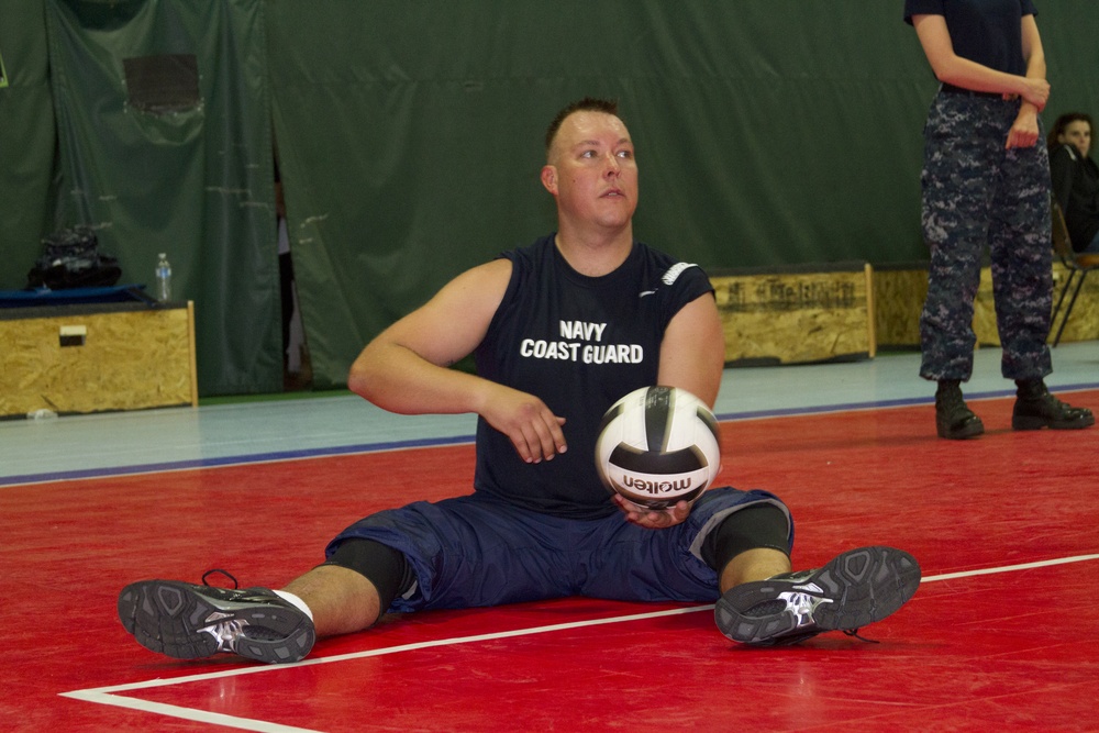 Navy Hospital Corpsman Tyler Burdick prepares to serve in a game of sitting volleyball.