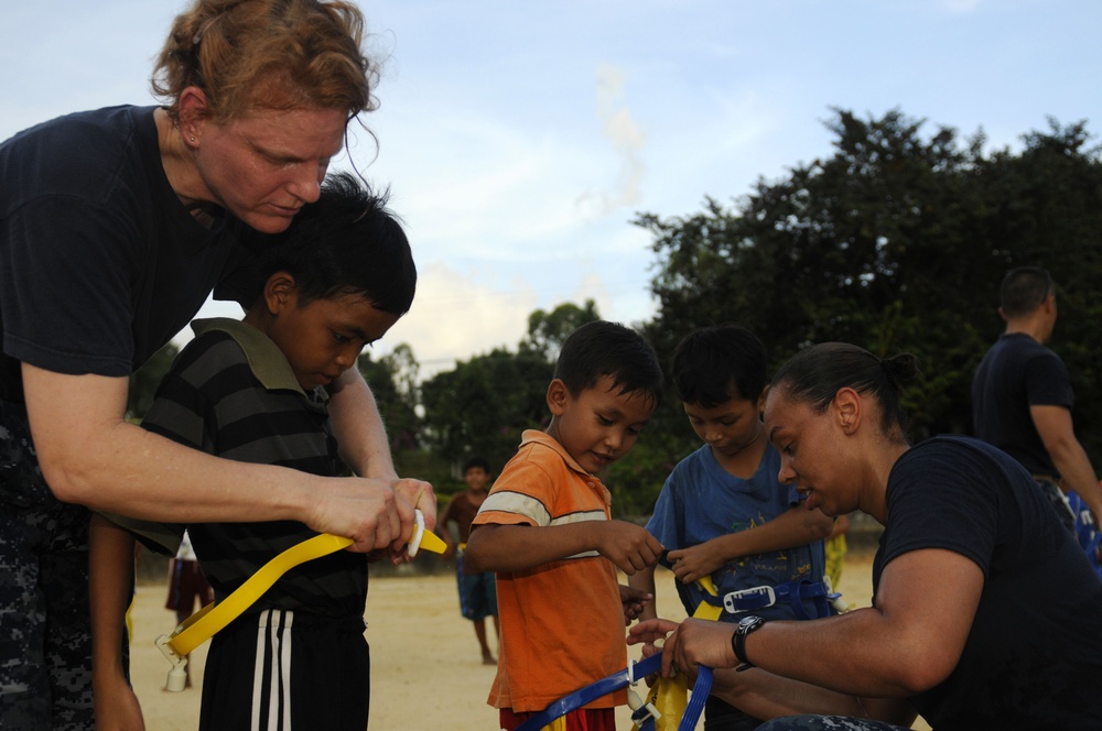 Blue Ridge sailors play games and music with Cambodian children