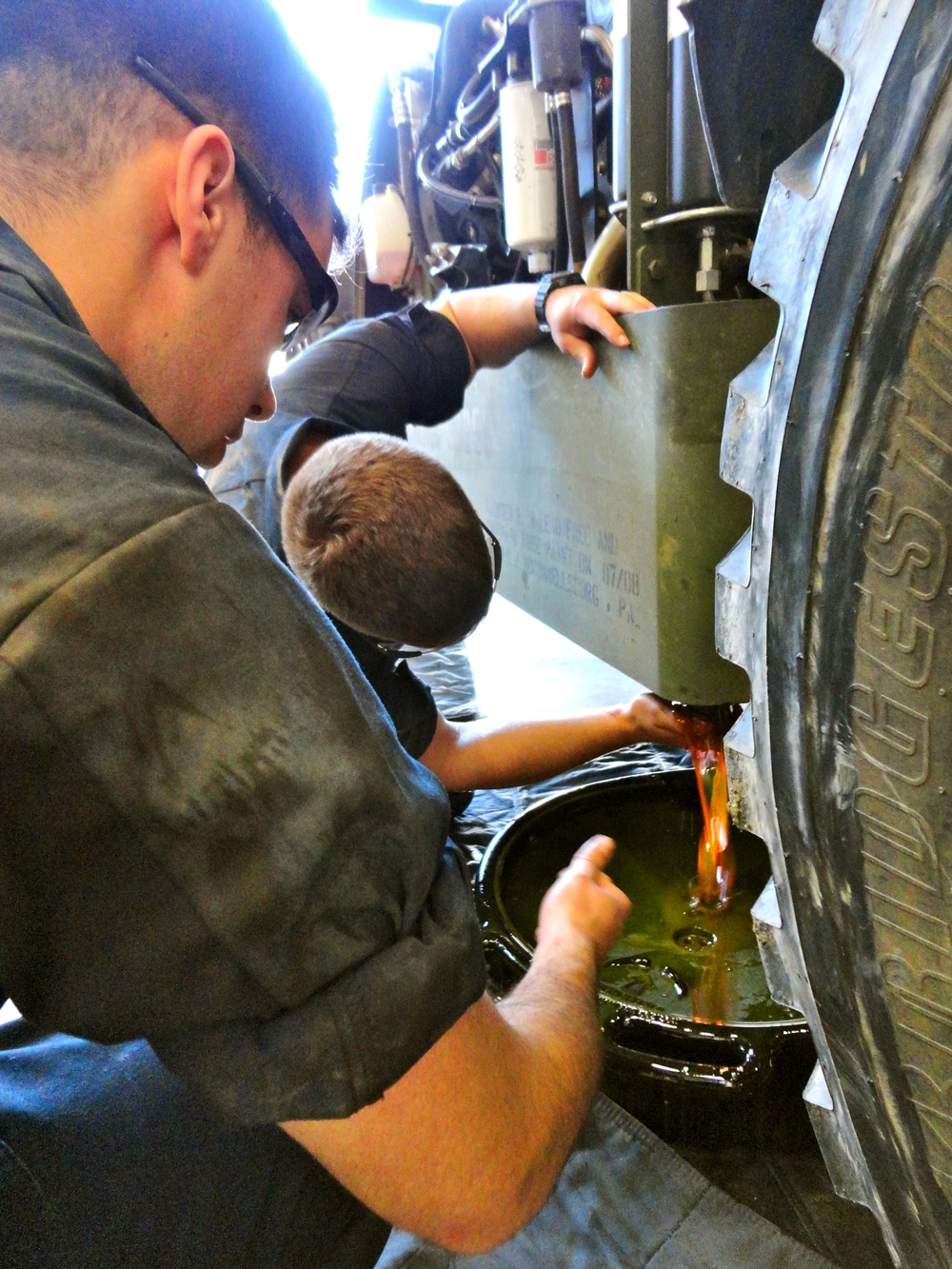 Construction mechanics drain oil from forlkift