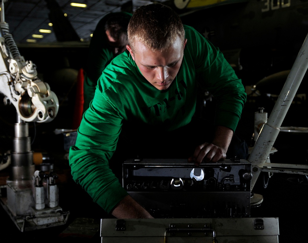 Performing maintenance on an F/A-18E Super Hornet
