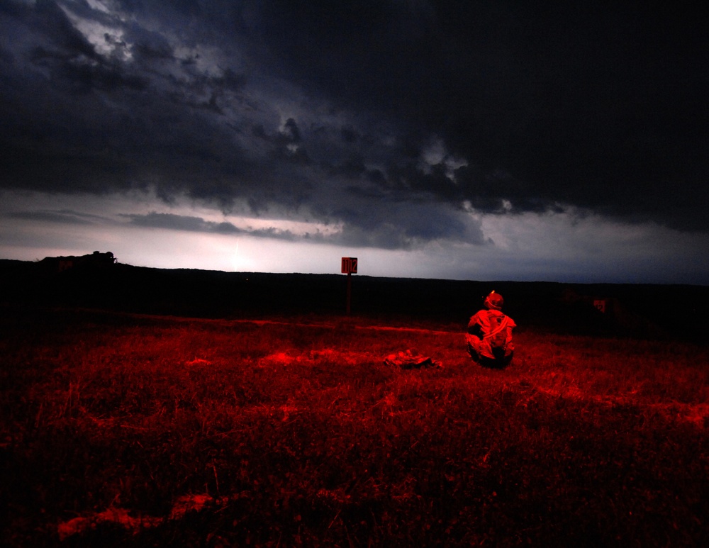 Indiana Army National Guardsmen assigned to the 38th Sustainment Brigade view a distant storm while conducting a night-fire qualification at Camp Atterbury