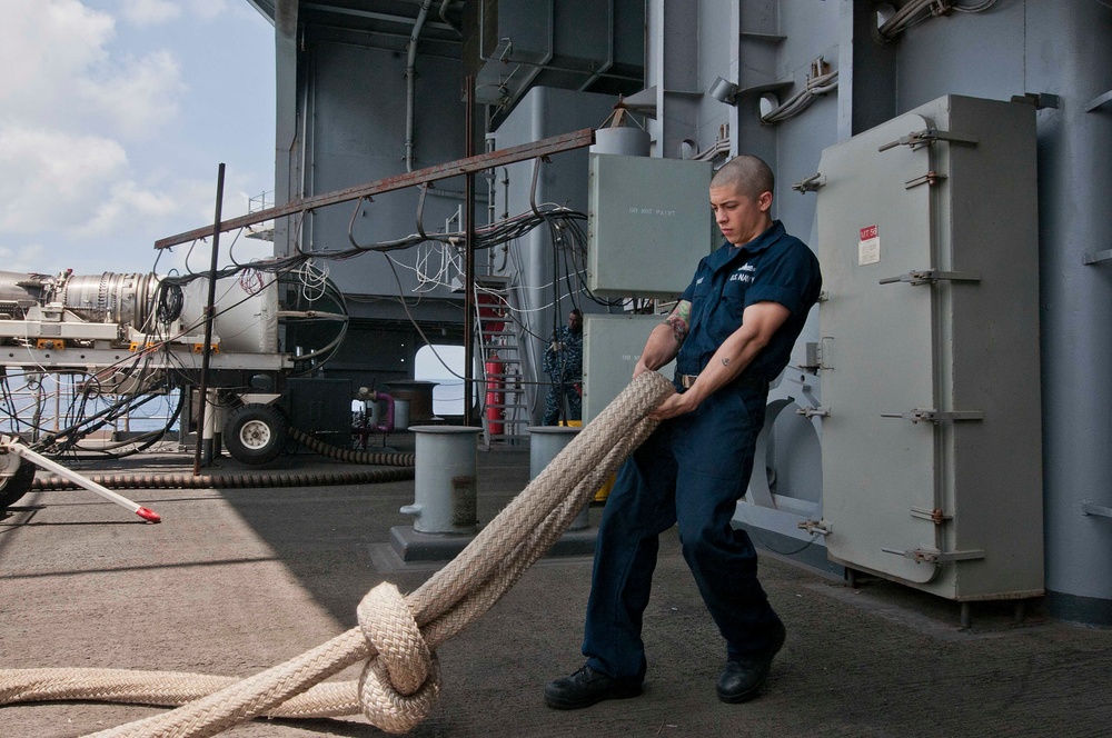 USS Dwight D. Eisenhower sailor lays out mooring lines