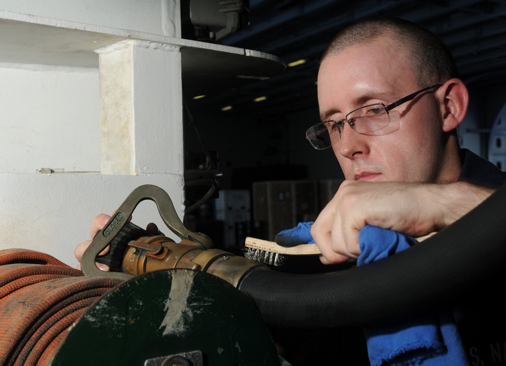 USS George H.W. Bush sailor cleans nozzle