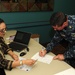 Sailor signs for transportation voucher