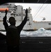 USS George Washington sailor gives signal