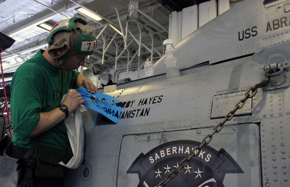 USS Abraham Lincoln sailor applies name to helicopter