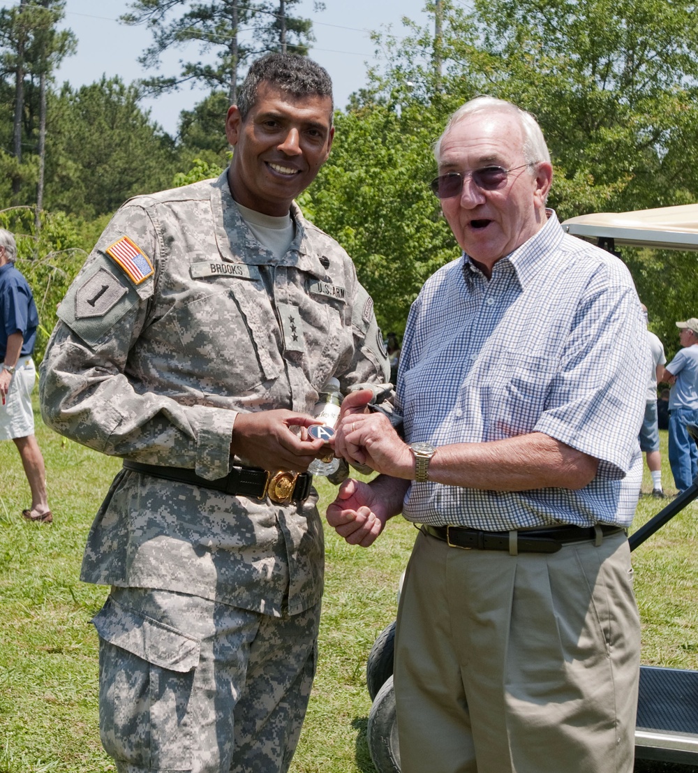 Retired general receives coin from former aide