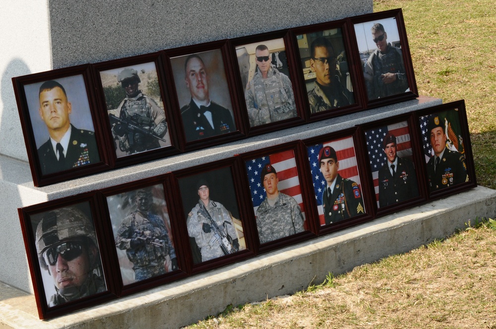 Photos of fallen paratroopers rest at the base of memorial