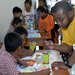 USS Vandegrift sailor work with Indonesian children