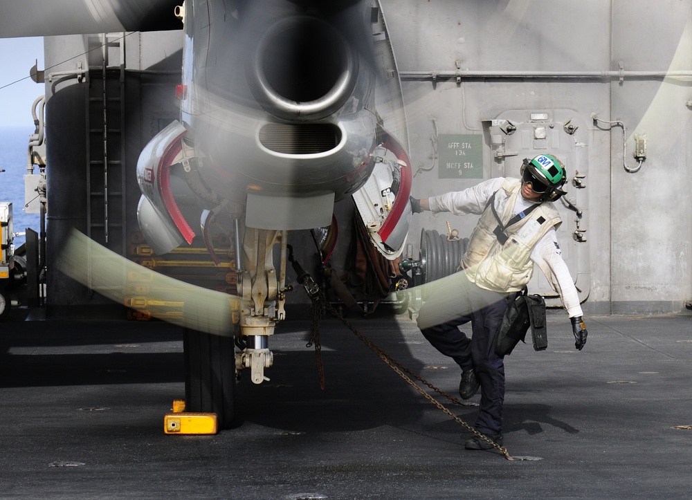 Inspecting the engine of an E-2C Hawkeye