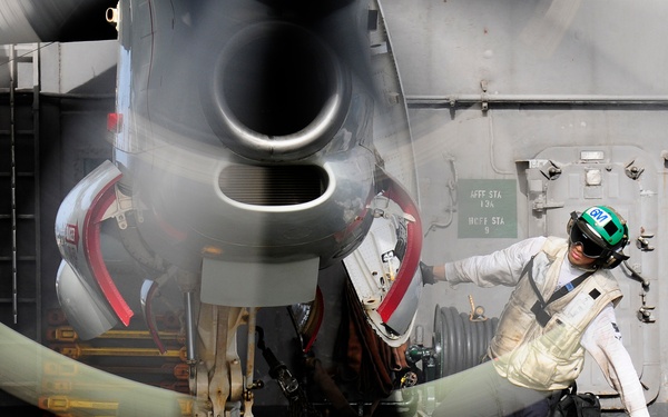 Inspecting the engine of an E-2C Hawkeye