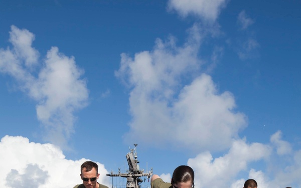 Marines, sailors wash USS Makin Island's flight deck