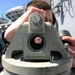 USS Nimitz sailor looks through telescopic alidade