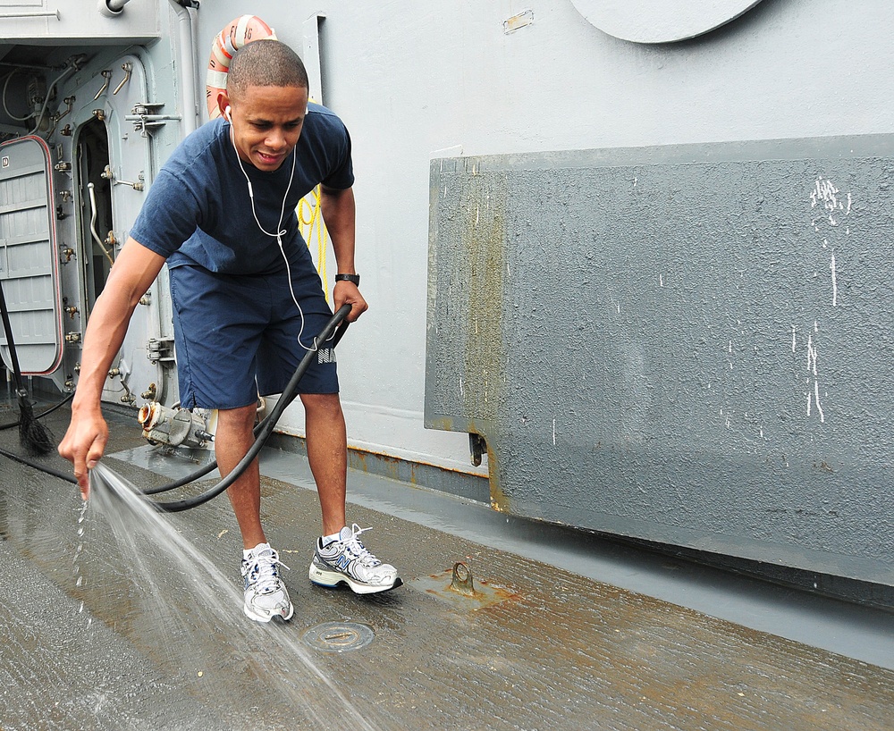 USS Underwood sailor sprays down ship floor
