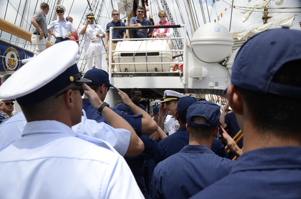 Coast Guardsmen and sailors salute as Navy Rear Adm. Greg Nosal, Commander, Carrier Strike Group 2, boards US Coast Guard Barque Eagle