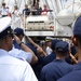 Coast Guardsmen and sailors salute as Navy Rear Adm. Greg Nosal, Commander, Carrier Strike Group 2, boards US Coast Guard Barque Eagle