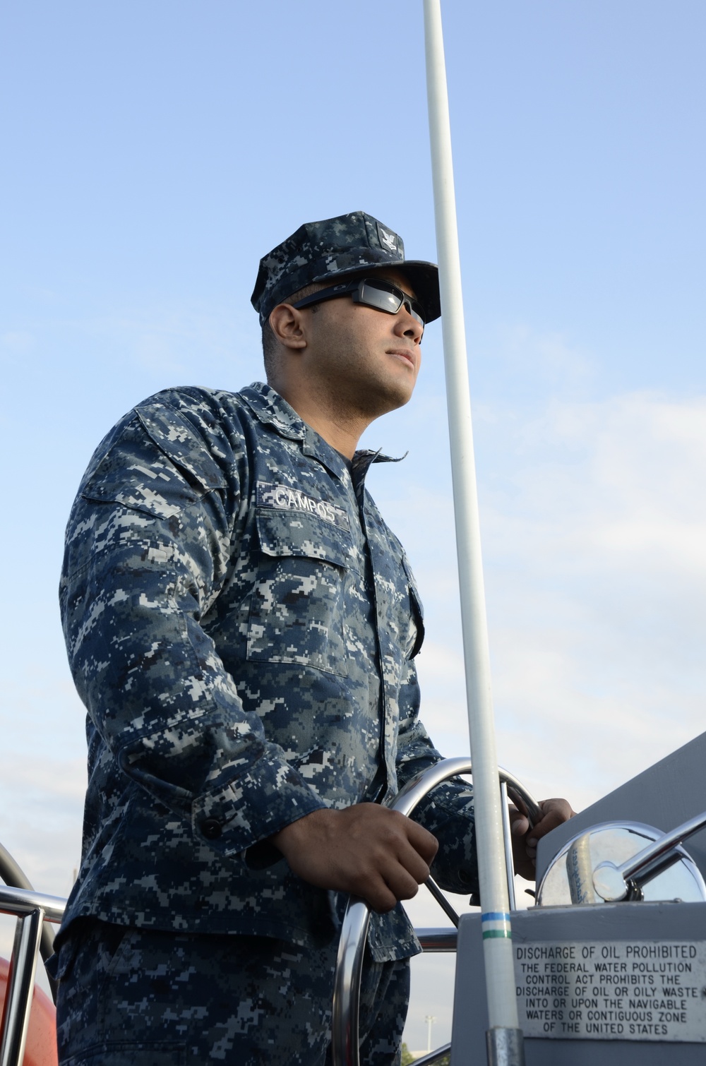 Boatswains Mate 2nd Class Danny Campos pilots a U.S. Naval Academy launch taking Coast Guardsmen to the U.S. Coast Guard Barque Eagle