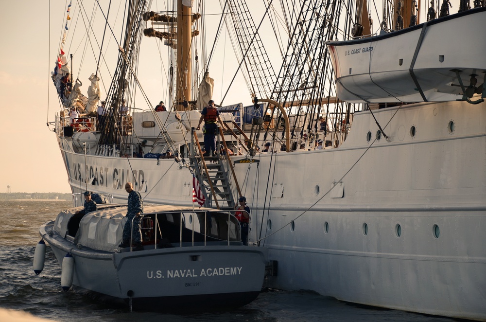 A US Naval Academy launch lies alongside U.S. Coast Guard Barque Eagle