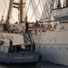 A US Naval Academy launch lies alongside U.S. Coast Guard Barque Eagle