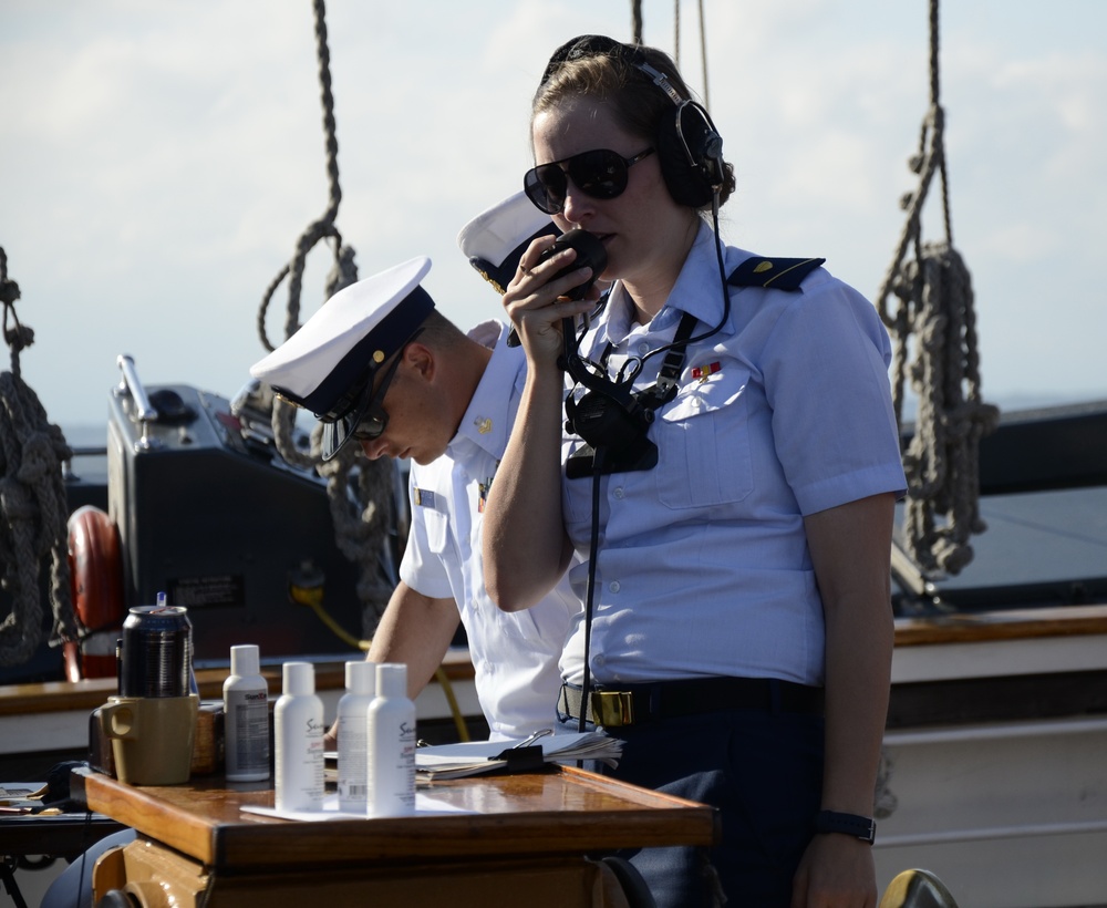 A Coast Guard Academy cadet, performing stern lookout watch duty, passes information into a sound powered telephone