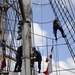 Coast Guardsmen work aloft above the deck aboard Coast Guard Barque Eagle