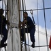 Coast Guardsmen work aloft above the deck aboard Coast Guard Barque Eagle