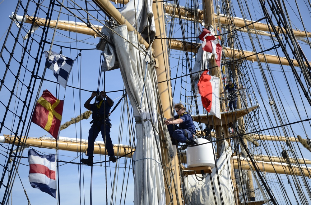 Coast Guardsmen work aloft above the deck