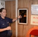 Coast Guard Food Service Specialist 3rd Class Donna Urton of Mobile, Ala., points out a plaque commemorating the maiden voyage of the Coast Guard Barque Eagle