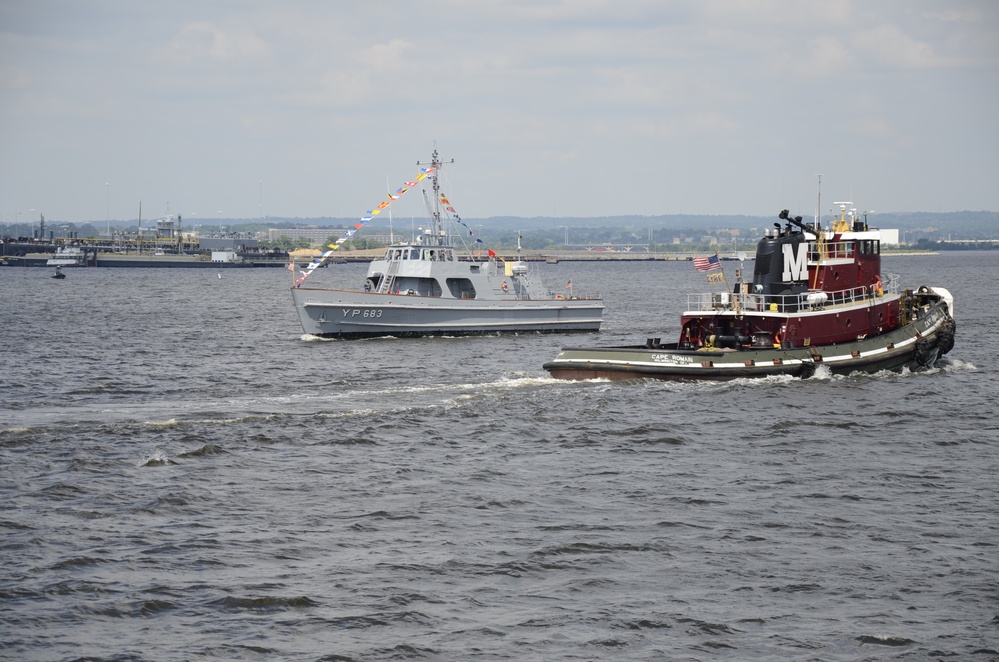 A US Naval Academy Yard Patrol craft passes alongside a Moran Towing Company tugboat