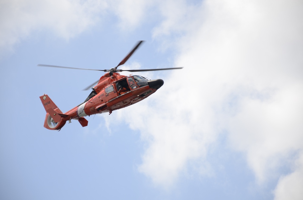 A Coast Guard MH-65C Dolphin helicopter patrols the waterways in and surrounding the Port of Baltimore