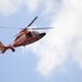 A Coast Guard MH-65C Dolphin helicopter patrols the waterways in and surrounding the Port of Baltimore