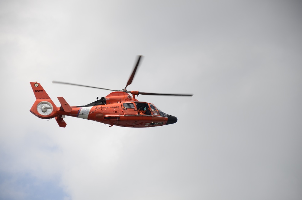 A Coast Guard MH-65C Dolphin helicopter patrols the waterways in and surrounding the Port of Baltimore during the Bicentennial of the War of 1812