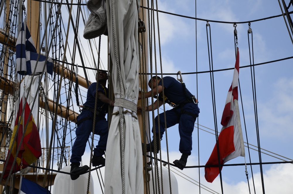 Coast Guardsmen work aloft above the deck aboard Coast Guard Barque Eagle