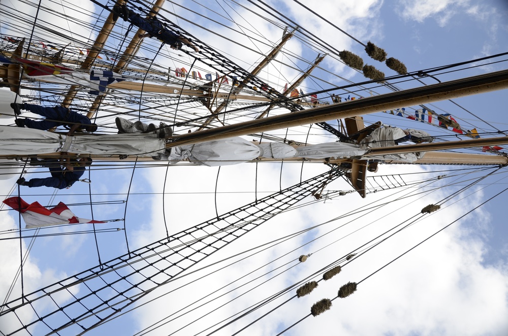 Coast Guardsmen work aloft above the deck aboard Coast Guard Barque Eagle