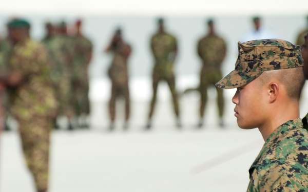 Marine Corps Cpl. Johnny Tau stands at attention as he awaits the command to unfurl the American flag during the opening ceremony for Exercise Tradewinds 2012
