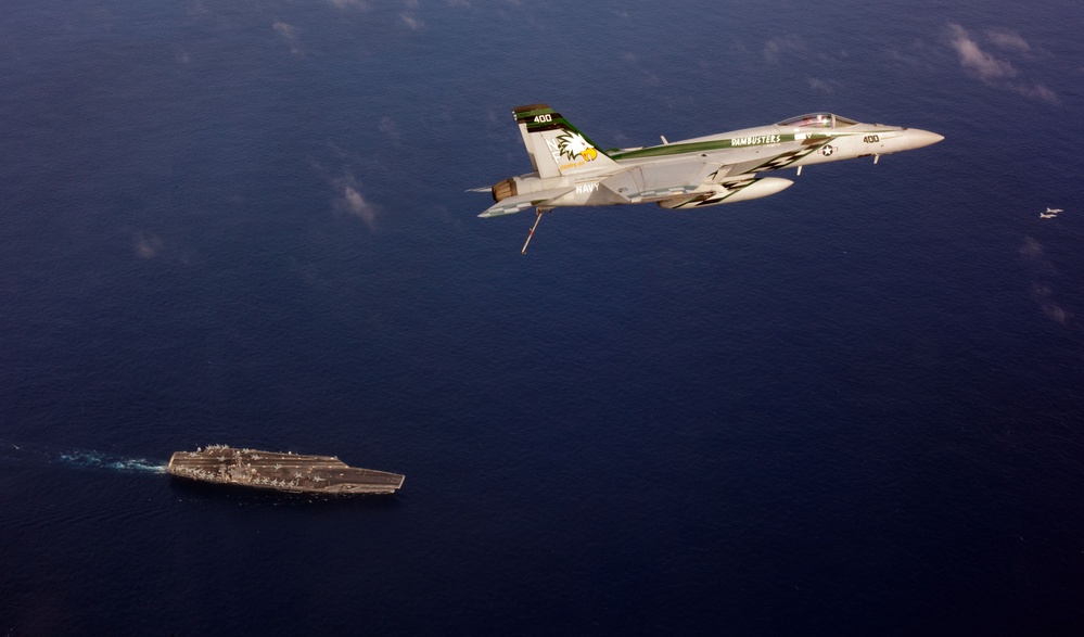 F/A-18E Super Hornet flies over USS George Washington
